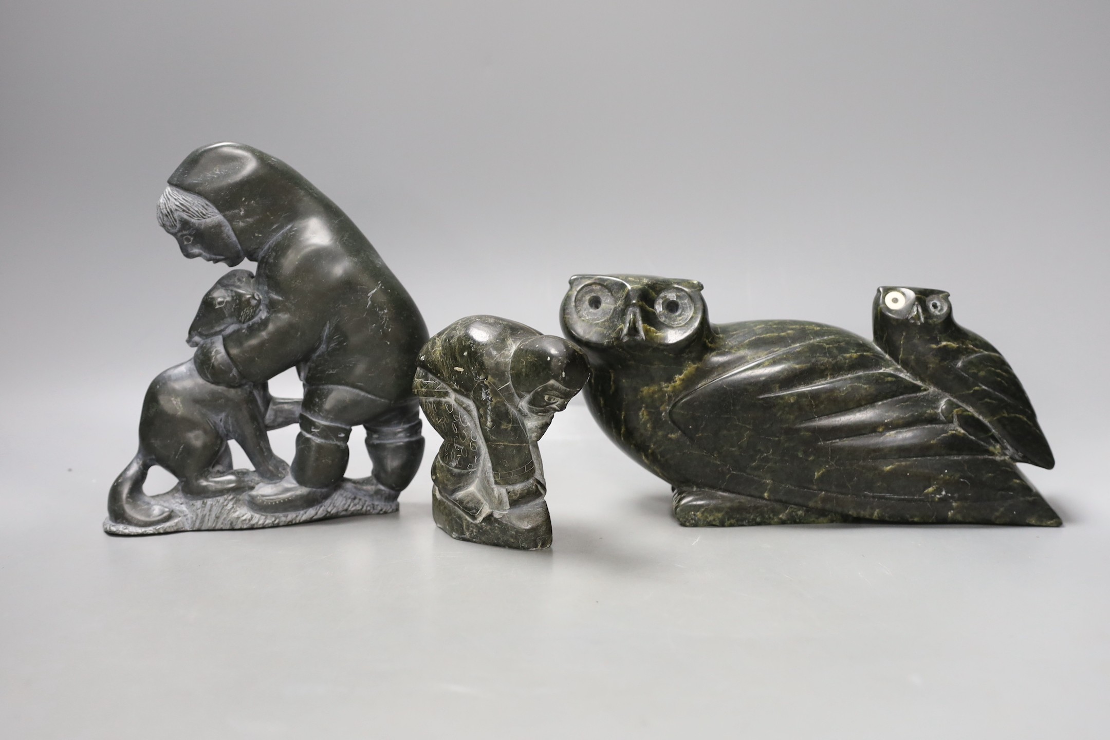 Three 20th century Inuit stone figure carvings, one bearing marine bone eyes - tallest 19cm